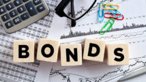 The word bonds on wooden cubes with office desktop. Business finance stock exchange concept.